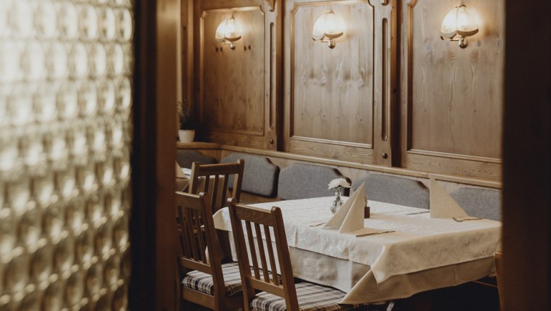 Im Innenraum ein ursprüngliches Ambiente, © Niederösterreich Werbung/Sophie Menegaldo Gemütlicher Gastraum mit Holzmöbeln und Tischdeko.