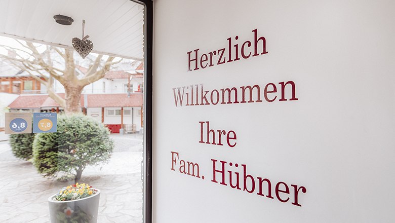 Herzlich Willkommen im Payerbacherhof!, © Payerbacherhof - Christopher Tarkus Eingangsbereich mit Begrüßungstext an der Wand und Blick nach draußen.