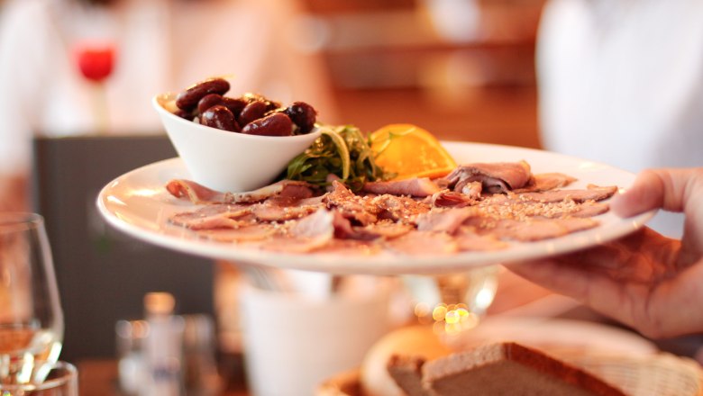 Feine Schmankerl Kerbl am Weinberg, © Philipp Toscani Ein Teller mit Aufschnitt und Oliven wird in einem Restaurant serviert.