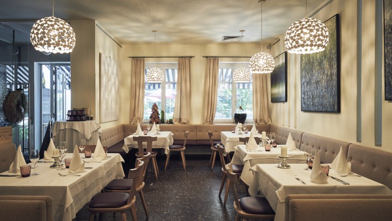 Haubenlokal mitten im Rohrwald im Bezirk Korneuburg, © Niederösterreich Werbung/Andreas Hofer Elegantes Restaurant mit gedeckten Tischen, modernen Lampen und Kunst an den Wänden.