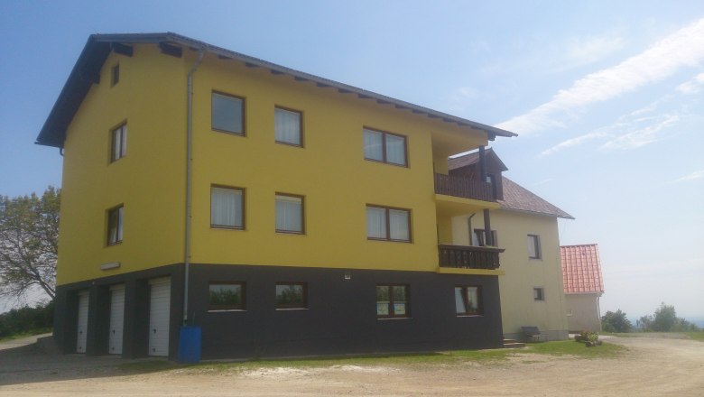 Anke's Ferienwohnung, © Anke Spreitzer Gelbes Gebäude mit mehreren Fenstern und Balkonen, blauer Himmel im Hintergrund.