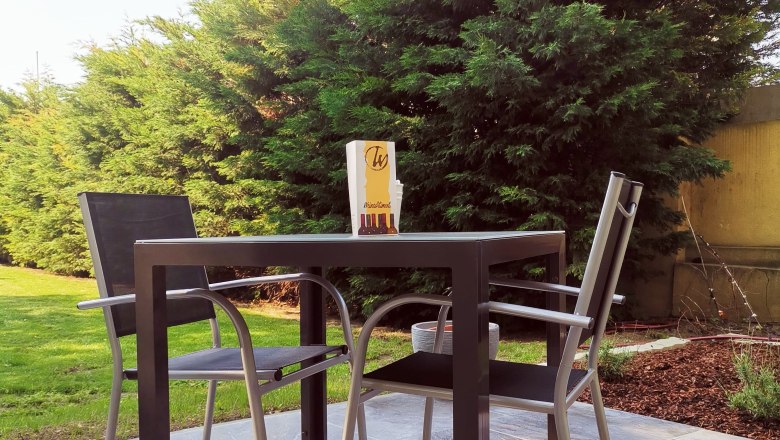 Terrasse, © Fam. Wißmann Terrasse mit Tisch, zwei Stühlen und Bäumen im Hintergrund.