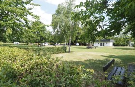 TDR-Campingplatz Zwentendorf, © Marika Ofner Stellplatz auf einer frisch gemähten Wiese. Om Hintergrund ein Häuschen für Sanitäranlage.
