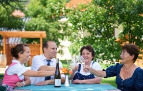 Gasthof 'Goldenes Schiff', © Paul Reiböck Vier Personen stoßen im Freien mit Weingläsern an einem Tisch an.