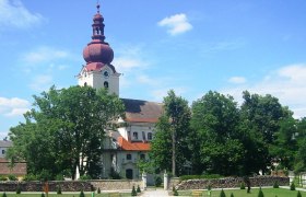 Jakob Prandtauer Kirche, © Marktgemeinde Ravelsbach Barockkirche mit rotem Turm und Garten im Vordergrund.