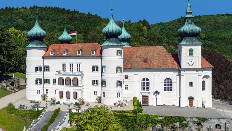 Schloss Artstetten, © M. Haslinger Schloss Artstetten mit Türmen und Gartenanlage vor bewaldetem Hintergrund.