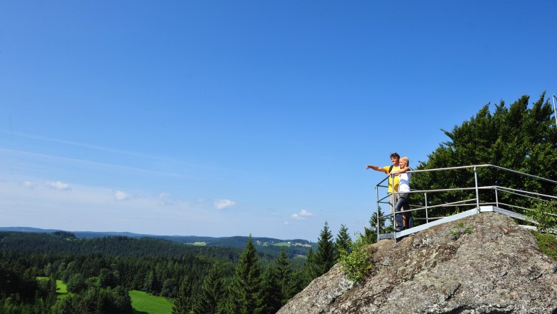 Bad Traunstein Wachtstein, © Bad Traunstein Zwei Personen stehen auf einem Aussichtspunkt auf einem Felsen und blicken in die Ferne über eine bewaldete Landschaft.