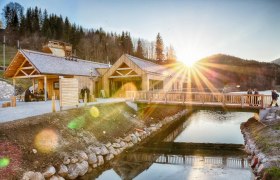Ötscher-Basis Wienerbruck, © Fred Lindmoser Ötscher-Basis Wienerbruck mit Holzgebäuden und Brücke bei Sonnenuntergang.