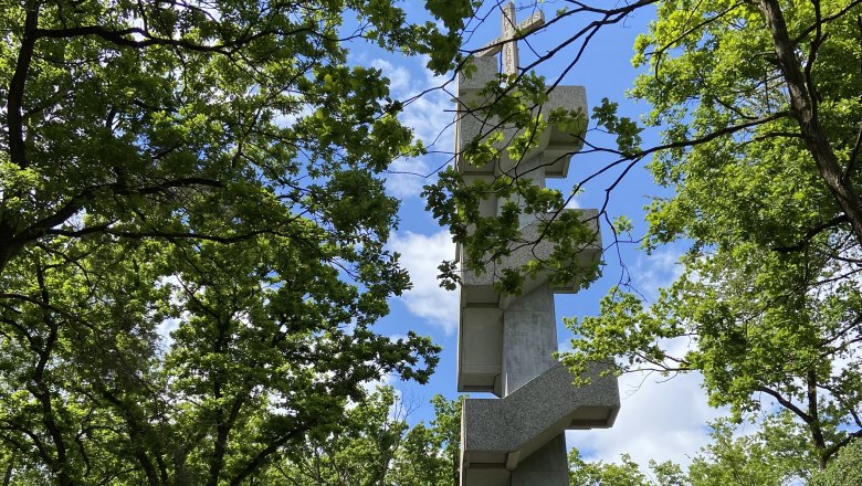 Europawarte Waitzendorf, © Weinstraße Weinviertel Ein moderner Aussichtsturm in einem Waldgebiet mit blauem Himmel.