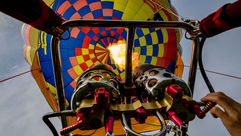 Ballontage Krems-Langenlois 2019, © Jürgen Übl Blick von unten auf einen Heißluftballon mit brennendem Brenner.