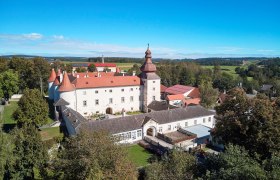 Schloss Dobersberg, © Waldviertel Tourismus, lichtstark.com Luftaufnahme von Schloss Dobersberg mit rotem Dach und umliegender Landschaft.