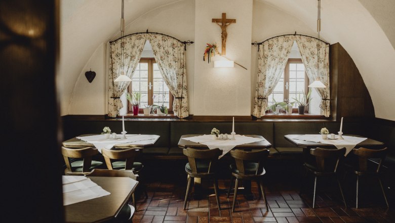 Traditionelle Stube, außergewöhnlich gute Küche, © Niederösterreich Werbung/Sophie Menegaldo Gemütliches Gasthaus mit Holzmöbeln und dekorativen Vorhängen.