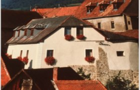 Appartment Kirchenblick in Weißenkirchen, © Familie Gattinger Weißenkirchen Historisches Gebäude mit roten Dächern und Blumenkästen in Weißenkirchen.