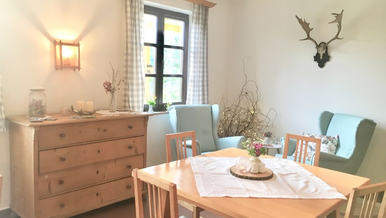 Frühstücksraum, © Fam. Ritz Gemütlicher Frühstücksraum mit Holztisch, Stühlen, Kommode und Dekorationen.