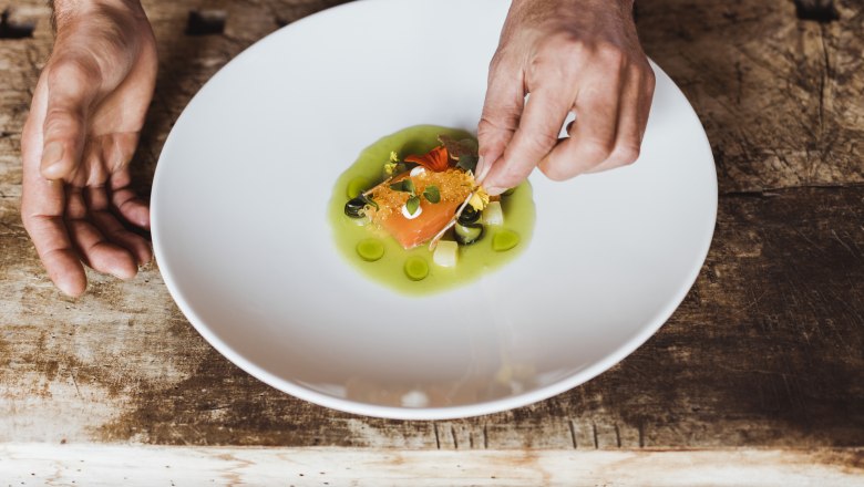 Leicht marinierte Ysper-Lachsforelle, Saiblingskaviar, © Niederösterreich Werbung/David Schreiber Ein Teller mit mariniertem Fisch und Kaviar, dekoriert mit grüner Sauce und Kräutern.