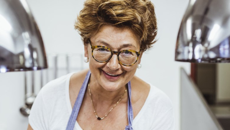 Roswitha Labenbacher, © Niederösterreich Werbung/David Schreiber Eine lächelnde Frau mit Brille und Schürze in einer Küche.