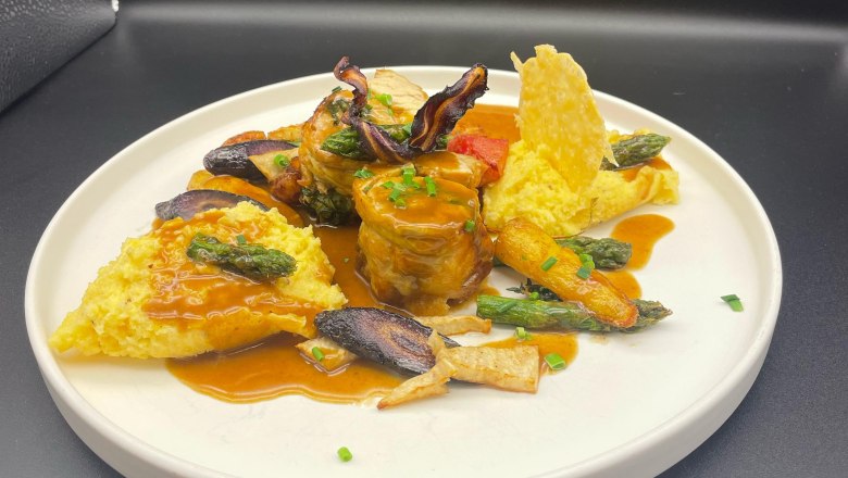 Speisen im das Freiherr, © Markus Jokesz Gourmetgericht auf weißem Teller mit Fleisch, Gemüse und Sauce.