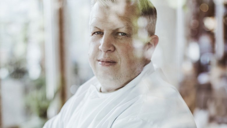 Wirt Christian Widgruber, © Niederösterreich Werbung/David Schreiber Porträt eines Mannes in weißem Hemd, durch ein Fenster fotografiert.