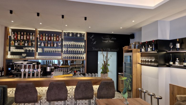 TD-Bar 4 Season, © Hendler Moderne Bar mit Flaschenregalen, Gläsern und Barhockern.