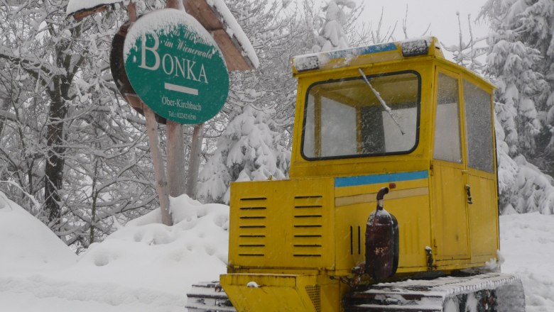Skigebiet Oberkirchbach, © Bonka GmbH Gelbes Schneefahrzeug im Schnee vor einem Schild mit der Aufschrift 'Bonka' in Oberkirchbach.