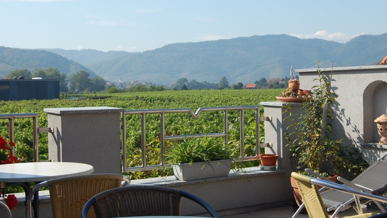 Terrasse Winzerhof Mörtinger, © Familie Mörtinger Terrasse mit Blick auf Weinberge und Berge im Hintergrund.
