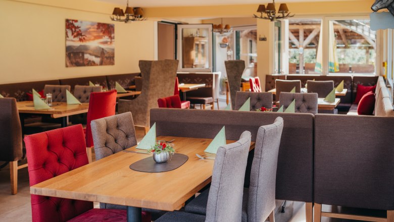 Platz nehmen & Ab Hof kaufen, © Niederösterreich Werbung/Daniela Führer Gemütliches Restaurant mit Holztischen und gepolsterten Stühlen.