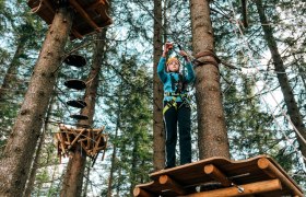 Waldseilgarten Hirschenkogel Semmering, © Semmering-Hirschenkogel Person im Kletterpark auf Plattform zwischen Bäumen.