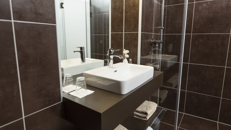 Badezimmer, © Ernst Jöchlinger Modernes Badezimmer mit Waschbecken, Spiegel und Dusche.