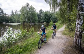 Rad fahren, Wasserlandschaftsradweg, Waldviertel, Naturpark Blockheide, © velontour.at Sanfte Radwege schlängeln sich entlang des glitzernden Wassers, umgeben von üppigem Grün und majestätischen Bäumen. Die frische Luft und das sanfte Plätschern des Wassers schaffen eine einladende Atmosphäre für Naturliebhaber und Radfahrer. Hier im Waldviertel wird jeder Moment zu einem unvergesslichen Erlebnis in der Natur.