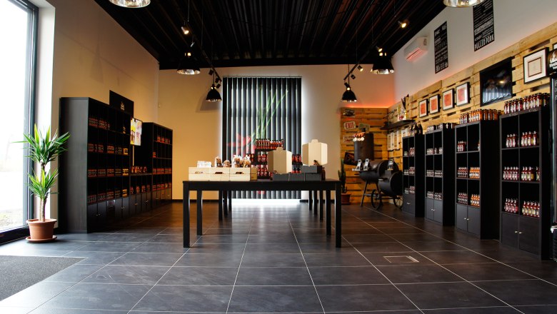 Shop Fireland Foods, © zVg Innenansicht eines modernen Ladens mit Regalen voller Produkte und einem Tisch in der Mitte.