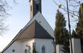 Gotische Kirche Kirchstetten, © Gotische Kirche Kirchstetten Gotische Kirche in Kirchstetten mit Turm und Statue im Vordergrund.