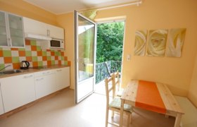 Küche und Essecke, © Patrizia Schiller Helle Küche mit Essecke, bunter Fliesenspiegel und offener Balkontür.