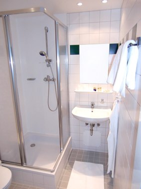 Bad, © Weinberger Kleines Badezimmer mit Dusche, Waschbecken und Handtüchern.