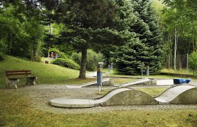 Minigolfanlage Herzogenburg, © weinfranz Minigolfanlage mit Betonbahnen und Bäumen im Hintergrund.