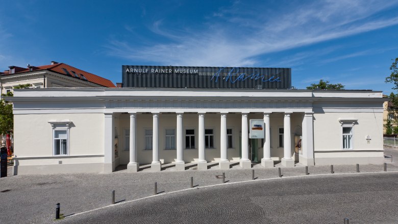 Arnulf Rainer Museum, © Kollektiv Fischka Außenansicht des Arnulf Rainer Museums mit Säulenfassade und blauem Himmel.