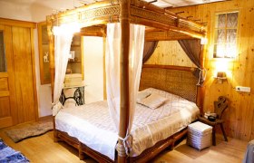 Cottage_Zimmer, © Familie Wolf Gemütliches Schlafzimmer mit Himmelbett aus Holz und rustikaler Einrichtung.