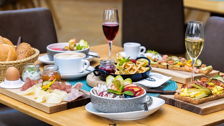 Eis-Greissler Kaffeehaus, Frühstück, © Blochberger Eisproduktion GmbH Frühstückstisch mit verschiedenen Speisen, Sektgläsern und Kaffee.