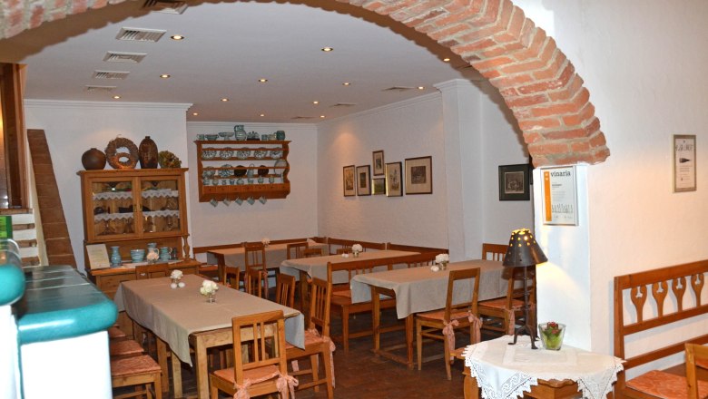 Heuriger, © Weinstube Aichinger Gemütlicher Innenraum eines Heurigen mit Holzmöbeln und Dekorationen.