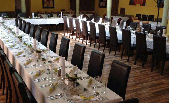 Dorfschenke-Oberzögersdorf, Hochzeitstafel, © Dorfschenke Oberzögersdorf Festlich gedeckte Hochzeitstafel in einem Raum mit gelben Wänden und Backsteinbögen.