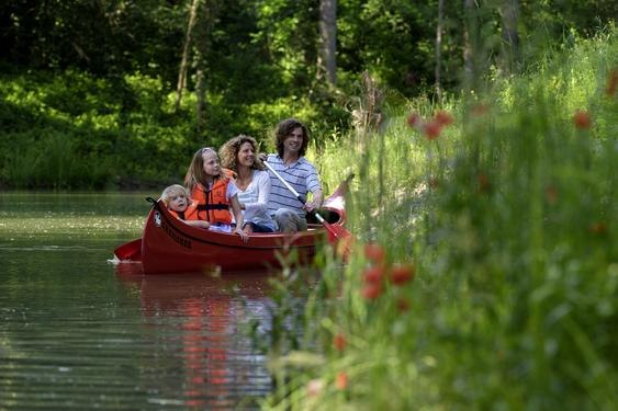 Kanufahren im Wasserpark, © DIE GARTEN TULLN Familie im Kanu auf einem Fluss im Grünen.