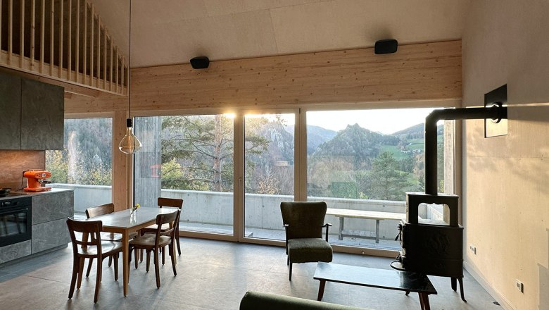 Wohn-/Essbereich, © Meinrad Hofer Moderner Wohn- und Essbereich mit großen Fenstern und Bergblick.