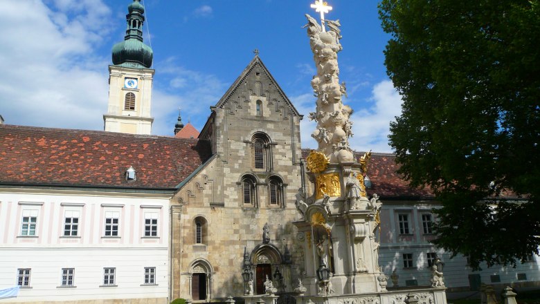 Innenhof Stift Heiligenkreuz, © Stift Heiligenkreuz Innenhof des Stifts Heiligenkreuz mit barocker Säule und Kirchturm.