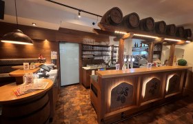 Rustikales Wirtshausflair, © Matthias Bachofner Rustikale Bar mit Holzverkleidung und Bierfässern als Dekoration.