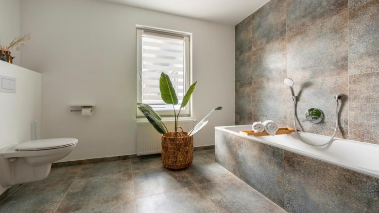 Badezimmer mit Badewanne, © Guestia GmbH Modernes Badezimmer mit Badewanne, Pflanze und Fenster.