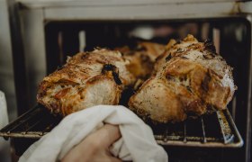 Schweinebratl direkt aus dem Ofen, © Niederösterreich Werbung/Rita Newman Frisch gebratenes Schweinefleisch wird aus dem Ofen genommen.