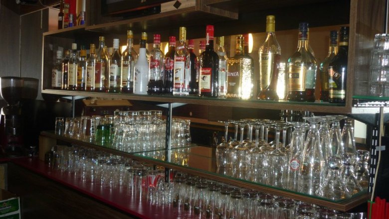 Café Bar Atlantis, Enzersdorf/Fischa, © Semir Koro Regal mit Flaschen und Gläsern in einer Bar.