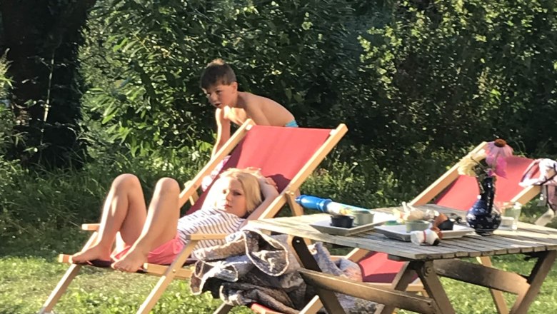 Kinder im Garten, © Monika Pölzer Zwei Kinder entspannen auf Liegestühlen im Garten.