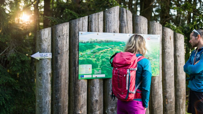 Am alpannonia Weitwanderweg, © Wiener Alpen/Martin Fülöp Zwei Wandernde betrachten eine Wanderkarte im Wald.