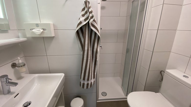 Zimmer Sommer, © Privatzimmer Leeb Modernes Badezimmer mit Dusche, Waschbecken und Toilette.