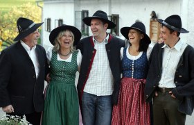 Rent A Sepp, © zVg Gruppe von fünf Personen in traditioneller bayerischer Tracht, die fröhlich lachen.